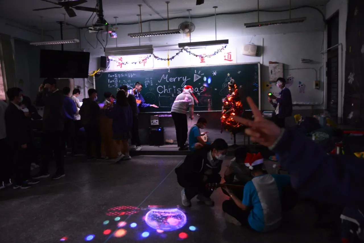 A Christmas party in a classroom, with a snowman effect reflected from the projector onto the middle of the floor.